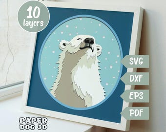 May include: A white polar bear with its head tilted up, looking at the sky. The bear is surrounded by a blue circle with white snowflakes. The image is labeled "10 layers" and "Paper Dog 3D".