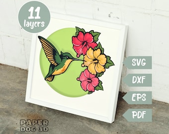 May include: A papercraft design featuring a green hummingbird with yellow and red hibiscus flowers. The design is made up of 11 layers and is available in SVG, DXF, EPS, and PDF formats.