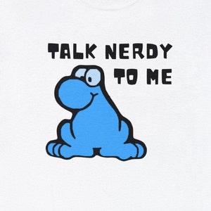 May include: White t-shirt with a blue cartoon character and the text "Talk Nerdy To Me".