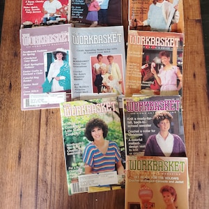 May include: A selection of vintage "Workbasket" magazines, displaying colourful covers with images of women and children. The magazines feature knitting, crochet, and needlework projects, with titles such as "Happy New Year!" and "Get Ready for Christmas!"
