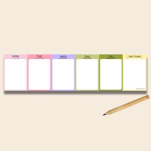 May include: A horizontal weekly planner notepad featuring six distinct coloured sections for Mon, Tue, Wed, Thu, Fri, and Sat/Sun, each with a white rectangular writing area. A wooden pencil with a black lead tip is positioned below the notepad.