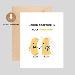 Puede incluir: Una tarjeta de felicitación blanca con el texto "JOINED TOGETHER IN HOLY MACARONI" presenta personajes de macarrones de dibujos animados. Un macarrón tiene una pajarita, y el otro lleva un velo y sostiene flores. Hay un sobre marrón detrás de la tarjeta.