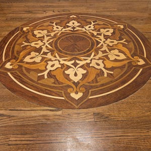 Beautifully intricate hardwood floor medallion made out of multi exotic wood species. Sketch Blue Studio