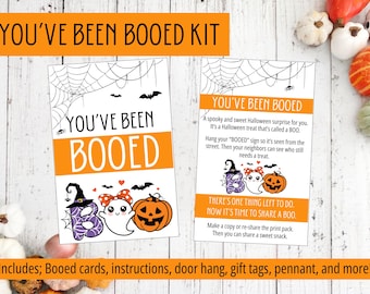 May include: A Halloween-themed kit with the text "YOU'VE BEEN BOOED" in orange and white. The kit includes cards, instructions, and gift tags. The design features bats, spiderwebs, and cartoon ghosts and pumpkins.