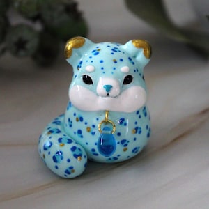 Pummeliger kleiner Schneepanther, handgefertigte Polymer Clay Figur mit Perle, niedliche Glücksbringer Dekoration, kleines kostbares Geschenk.