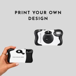 May include: Two disposable cameras with a white and black color scheme. The cameras feature a customizable white area with the text "YOUR DESIGN HERE" printed on the front. The text "PRINT YOUR OWN DESIGN" is displayed above the cameras.