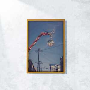 Crane Hoisting Disco Ball Print: Industrial Cityscape Wall Art