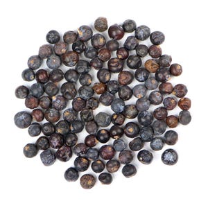 May include: A collection of dried juniper berries, varying in shades of blue, purple, and brown, scattered on a white surface. The berries have a slightly wrinkled texture and are of various sizes, suggesting a natural, organic product.