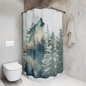 May include: A shower curtain featuring a watercolor design of a howling wolf in a forest. The artwork uses shades of blue, green, and white to depict the wolf and the surrounding trees. The curtain is hanging in a bathroom setting.