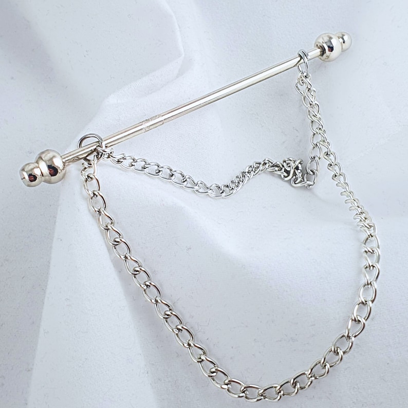 Op de afbeelding: Zilveren stropdasgesp met een ketting en twee ronde bolvormige uiteinden.