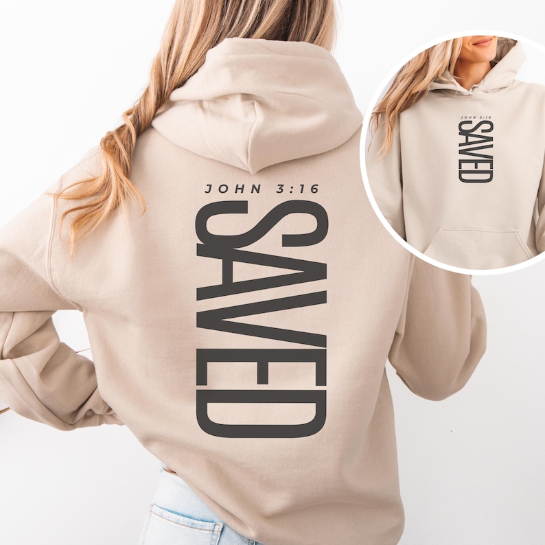 May include: Beige hoodie with the word "SAVED" printed vertically in large, black letters on the back. The text "JOHN 3:16" is above the word "SAVED". A smaller image of the hoodie is in the upper right corner.
