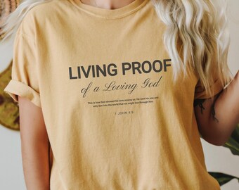 May include: A yellow t-shirt with the text "LIVING PROOF of a Loving God" and the Bible verse "1 JOHN 4:9".