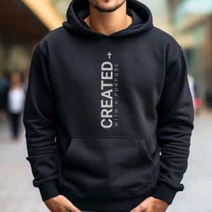 May include: Black hooded sweatshirt with the text "CREATED + WITH A PURPOSE" in white lettering.