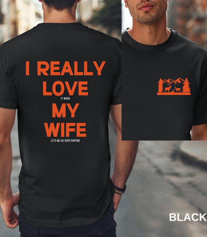 K&ouml;nnte beinhalten: Schwarzes T-Shirt mit orangefarbenem Text, der "Ich liebe meine Frau wirklich, wenn sie mich zum Hirschjagen l&auml;sst" lautet. Die R&uuml;ckseite des Shirts hat eine kleine orangefarbene Grafik einer Bergszene mit zwei Hirschen.