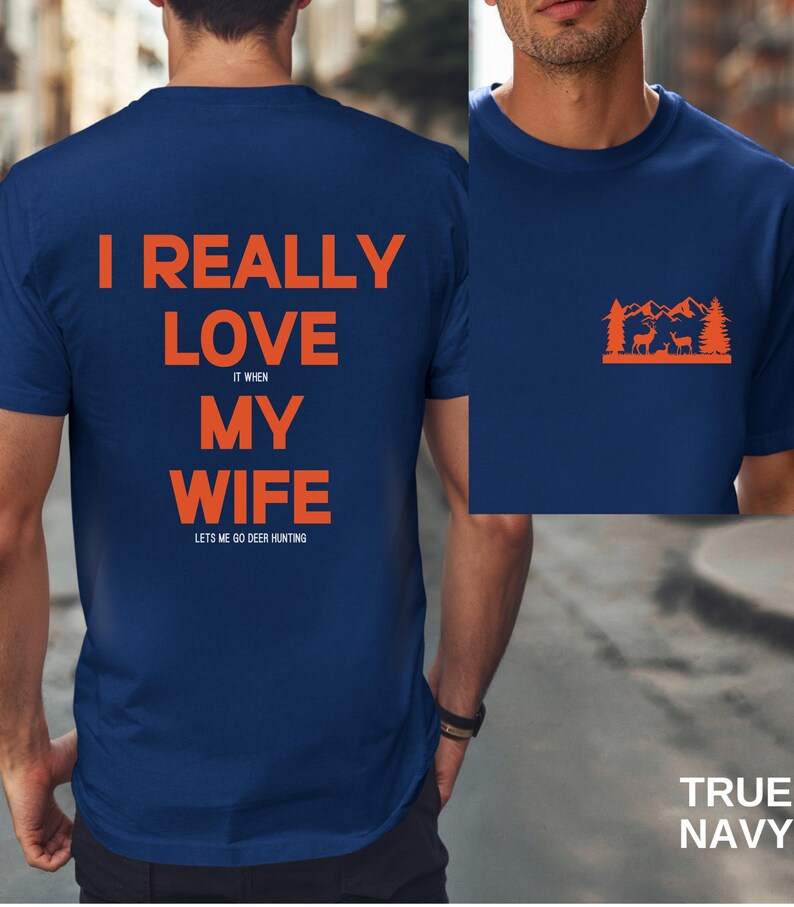 K&ouml;nnte beinhalten: Ein marineblaues T-Shirt mit dem Text "I really love my wife it when lets me go deer hunting" auf der R&uuml;ckseite und einer Silhouette eines Hirsches in einem Wald auf der Vorderseite.