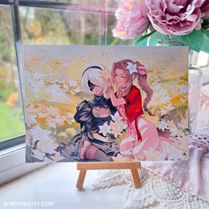 May include: A print featuring two anime characters, one with long blonde hair and a red dress, the other with short white hair and a black dress, standing in a field of white flowers.