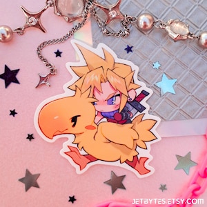 May include: A sticker featuring a cartoon illustration of a blonde-haired character riding a yellow bird. The character is wearing a blue and purple outfit and holding a sword. The sticker is on a pink background with silver stars.