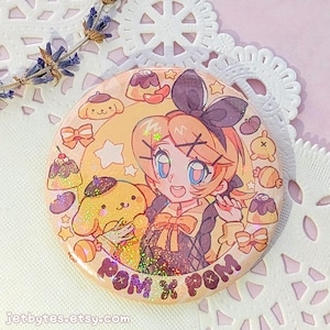 May include: A circular pin-back button featuring a glittery anime-style illustration of a character with a dark bow and a yellow dog-like creature. The design includes small puddings, bows, and stars with the text POM X POM printed at the bottom.