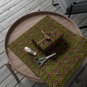 May include: A green and red patterned gift wrap with a brown bow on a gift box. The gift wrap has a geometric pattern of overlapping triangles.
