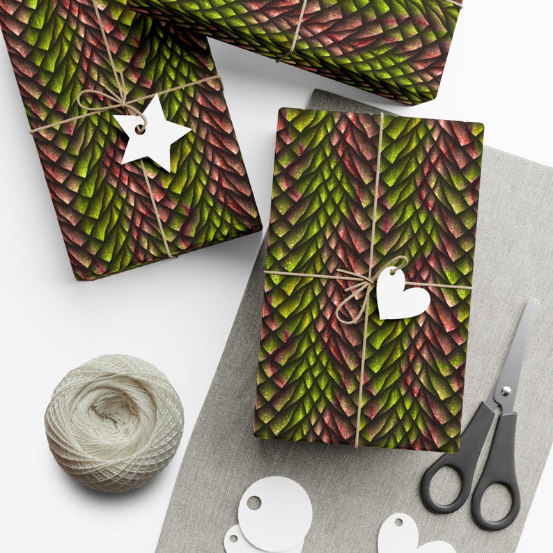 May include: Three gift boxes wrapped in green and red dragon scale patterned wrapping paper. The boxes are tied with twine and decorated with white paper stars and hearts.