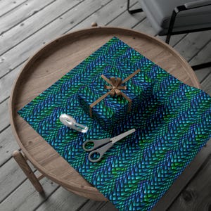 May include: A blue and green patterned wrapping paper with a geometric design. A small gift box is wrapped in the paper and tied with a brown ribbon.