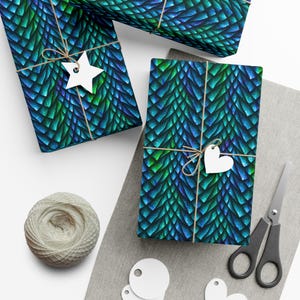 May include: Three gift boxes wrapped in blue and green dragon scale patterned wrapping paper. The boxes are tied with twine and decorated with white paper stars and hearts.