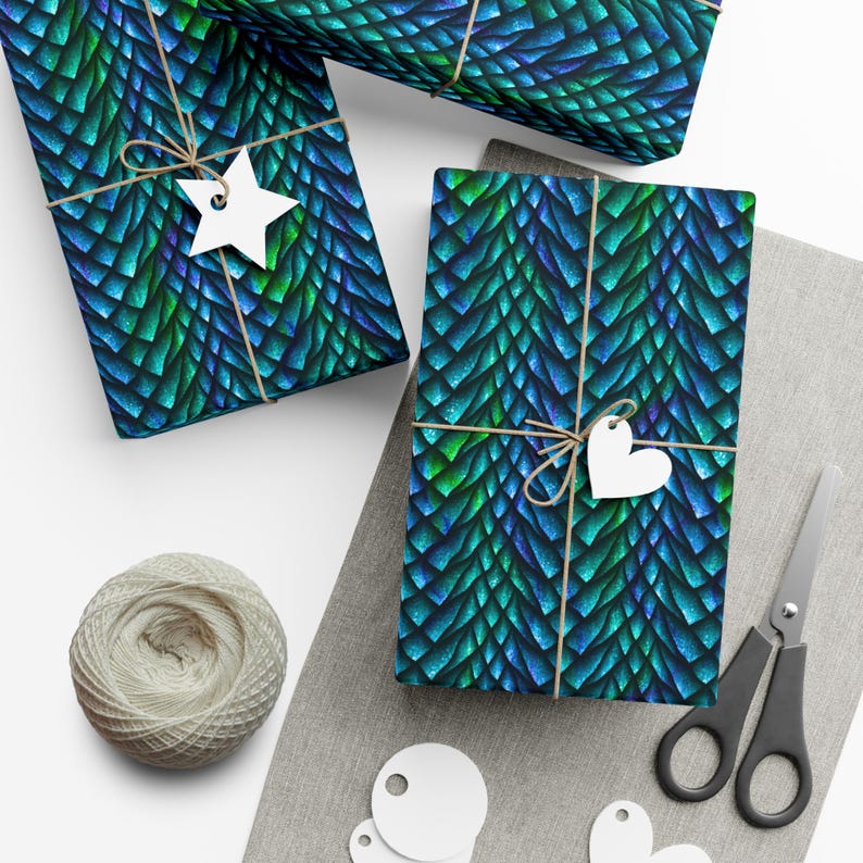 May include: Three gift boxes wrapped in blue and green dragon scale patterned wrapping paper. The boxes are tied with twine and decorated with white paper stars and hearts.