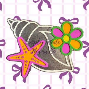May include: A decorative seashell design with a starfish and flower. The seashell is gray with a white outline and glitter accents. The starfish is orange with pink trim, and the flower has pink and orange petals with a green outline. The text "Simply Made Mama Co" is on the seashell.
