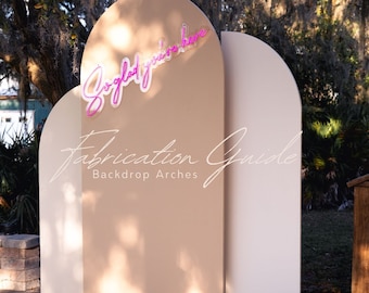 May include: A fabrication guide for backdrop arches, featuring three arches in beige and white. The arches are arranged in a staggered formation, with the largest arch in the center. The text "So glad you're here" is displayed in pink neon lettering on the largest arch.
