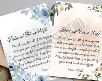 Puede incluir: Dos tarjetas de felicitación con detalles florales y el texto "Beloved Elders Wife". Una tarjeta tiene flores azules, la otra flores color crema. Las tarjetas están sobre un fondo neutro.