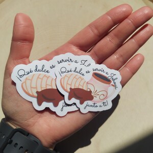 Peut inclure: Autocollants blancs avec le texte "&iexcl;Qu&eacute; dulce es servir a Jehov&aacute;!" et "junto a ti!". Ils pr&eacute;sentent des illustrations d'une p&acirc;tisserie concha, d'une tasse de caf&eacute; et d'un cochon en chocolat. Les autocollants sont dans une main.