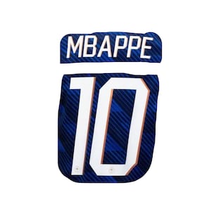 May include: A blue and white soccer jersey with the name "MBAPPE" across the top and the number "10" in large white numerals. The jersey has a subtle pattern and small emblems.
