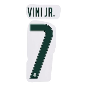 Peut inclure: Un transfert thermocollant vert foncé présentant le texte VINI JR. au-dessus d'un grand chiffre 7. Le chiffre 7 comprend un fin contour blanc et un petit emblème blanc en bas. Le motif est présenté sur un support en papier blanc.