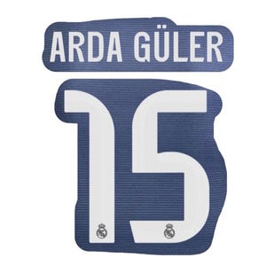 May include: A navy blue patch featuring the name "ARDA GÜLER" in white lettering above the number "15". The number is white, with the Real Madrid logo at the base of each digit.