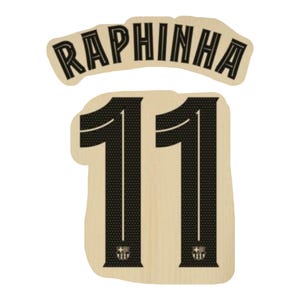 Può includere: Una toppa beige chiaro con il nome "RAPHINHA" in nero, testo curvo sopra il numero "11". Il numero "11" è nero con un motivo strutturato e un piccolo emblema in basso. Probabilmente per una maglia sportiva.