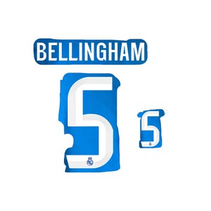 May include: A blue and white graphic design featuring the name "BELLINGHAM" above a blue number "5". The number "5" is in a stylized font, with a smaller version of the number to the right. The Real Madrid logo is visible.