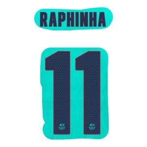 Op de afbeelding: Een turquoise sportshirt-afbeelding met de naam RAPHINHA in donkerblauwe hoofdletters boven het nummer 11. Het nummer 11 is donkerblauw met een subtiel stippenpatroon en een klein embleem aan de onderkant van elk cijfer op een turquoise achtergrond.