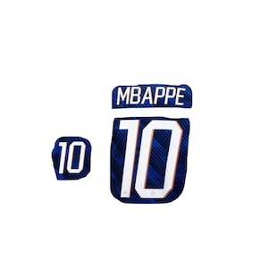 May include: A blue and white soccer jersey fragment with the name "MBAPPE" above the number "10". The number "10" is also displayed on a smaller patch. The jersey has a diagonal striped pattern.