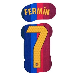 Op de afbeelding: Een sportshirt naam- en nummersticker met de naam FERMÍN in gele letters boven een groot geel nummer 7. De achtergrond bestaat uit verticale blauwe en rode strepen met een textuur en een klein embleem aan de onderkant van het cijfer 7.