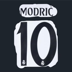 Puede incluir: Número de camiseta blanco y negro 10 con el nombre "MODRIĆ" encima.