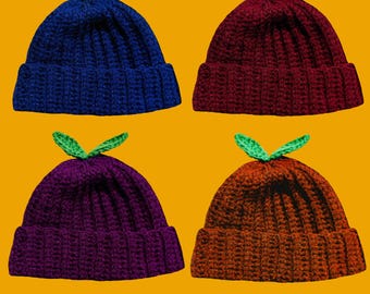 May include: Four crocheted beanies with green leaf accents. The beanies are in blue, burgundy, purple, and orange.