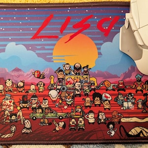 May include: A rectangular mouse mat with a vibrant cartoon illustration, the name "LISA" in red, and a sunset scene with mountains and cartoon characters. A white and grey wireless mouse is positioned on the right side.