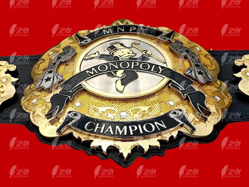 May include: A gold and black championship belt with a Monopoly Man logo and the words "MONOPOLY CHAMPION".