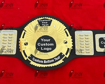 May include: A black and gold championship belt with space for custom logos and text. The center plate features a gold eagle design. The belt is displayed on a red background.