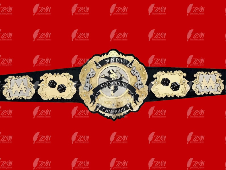 May include: A gold and black championship belt with a Monopoly board game theme. The center plate features a Monopoly Man figure and the words "MONOPOLY CHAMPION". The side plates feature dice and the letter "A" in a stylized font.