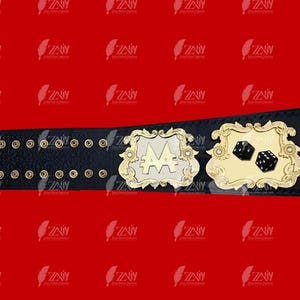 May include: A black leather championship belt with gold accents. The belt features a large, silver plate with the letters "AA" in the center. The belt also has a smaller gold plate with two dice on it.