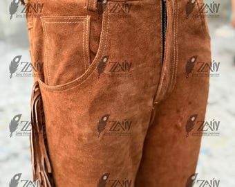 May include: Brown suede leather pants with fringe detailing along the sides. The pants feature a zipper fly, belt loops, and pockets. The stitching is a lighter brown color, creating a contrast against the suede. A classic western wear style.