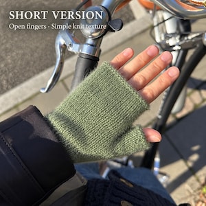 May include: Sage green fingerless gloves featuring a simple knit texture. The text on the image reads SHORT VERSION Open fingers · Simple knit texture. These gloves cover the palm and wrist while leaving the fingers exposed for dexterity.
