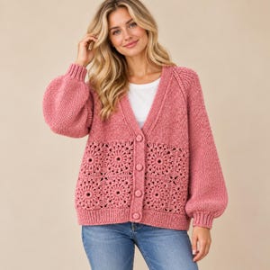 May include: A dusty rose cardigan featuring a V-neckline, long balloon sleeves with ribbed cuffs, and a button-down front. The lower portion of the garment is constructed from a series of square crochet motifs with a central floral pattern.