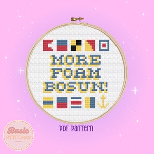 Op de afbeelding: Een kruissteekpatroon met nautische vlaggen en de tekst "MORE FOAM BOSUN!" in een witte hoepel. Het patroon is beschikbaar als PDF-download.